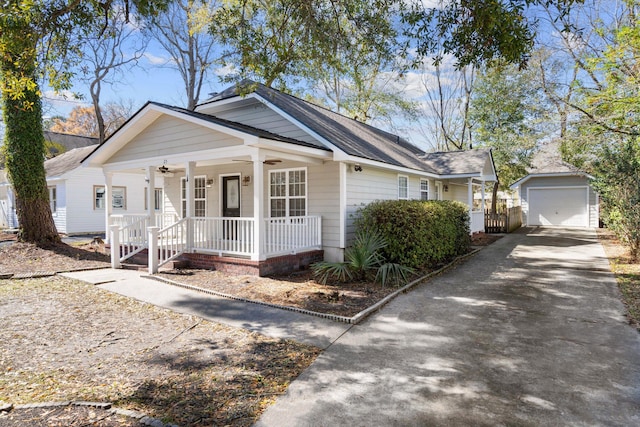 bungalow-style house featuring a detached garage, a porch, concrete driveway, an outdoor structure, and a ceiling fan