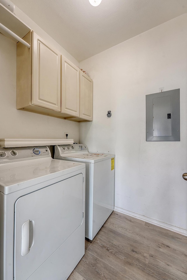 130 River Landing Dr Unit 2310, Daniel Island, SC 29492 - laundry area featuring electric panel, cabinet space, washing machine and clothes dryer, light wood-style floors, and baseboards