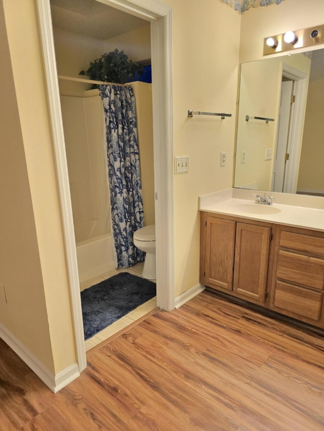 full bathroom with wood-type flooring, toilet, vanity, and shower / bath combo with shower curtain