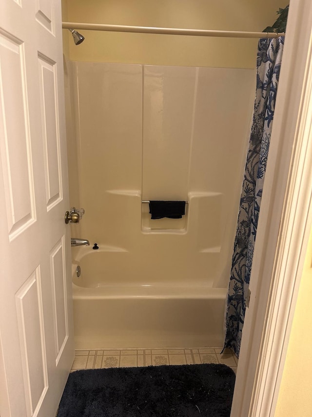 bathroom with tile patterned floors and shower / bath combo with shower curtain