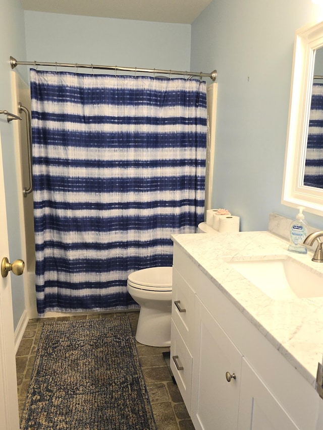 bathroom with walk in shower, vanity, and toilet