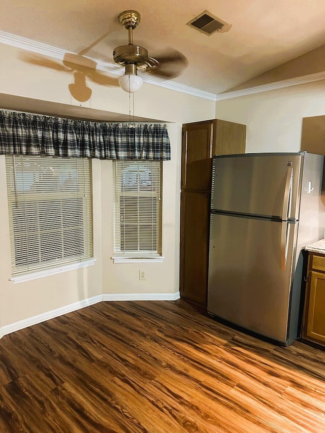 unfurnished dining area featuring hardwood / wood-style flooring, ceiling fan, ornamental molding, and a textured ceiling