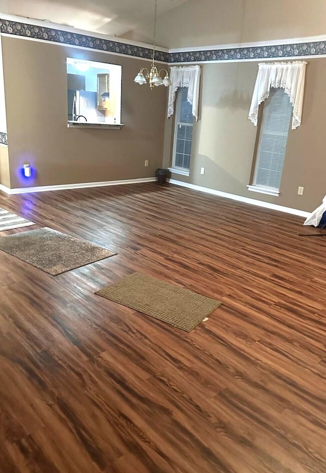 interior space with lofted ceiling, hardwood / wood-style floors, and a chandelier