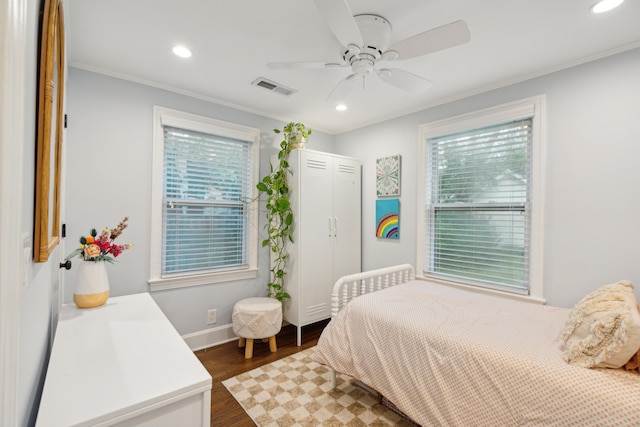 bedroom with dark wood-type flooring, ceiling fan, and crown molding