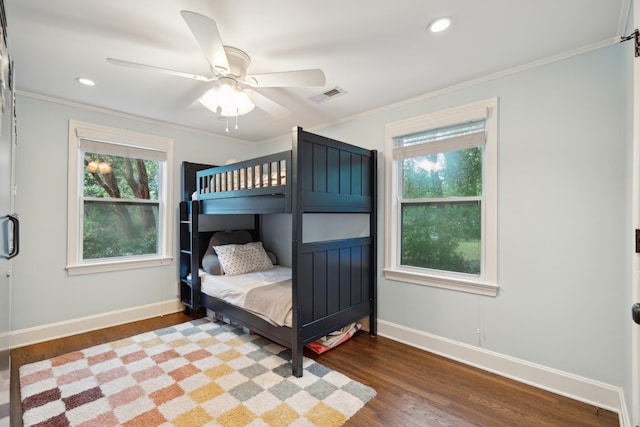 bedroom with hardwood / wood-style flooring, ceiling fan, multiple windows, and ornamental molding