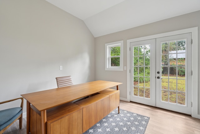 office featuring lofted ceiling, french doors, and light hardwood / wood-style flooring