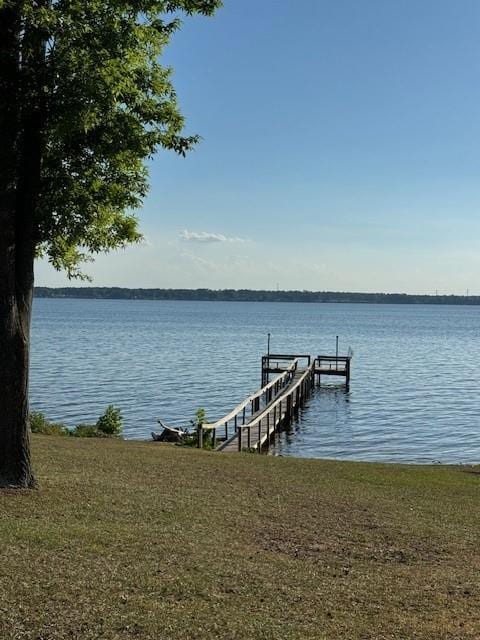 dock area featuring a water view and a yard