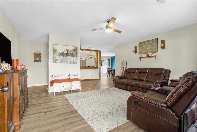 living room featuring a textured ceiling, hardwood / wood-style flooring, and ceiling fan