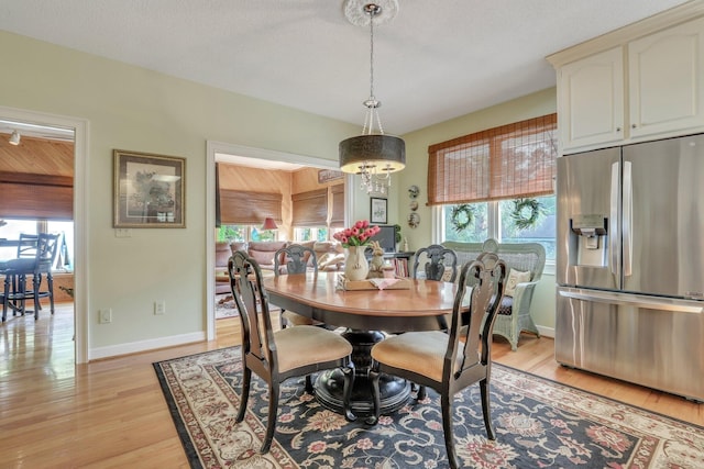 dining space featuring a textured ceiling and light wood-type flooring