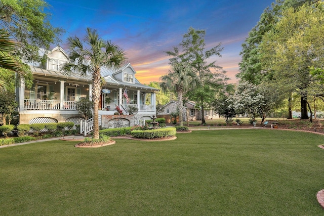 yard at dusk featuring covered porch