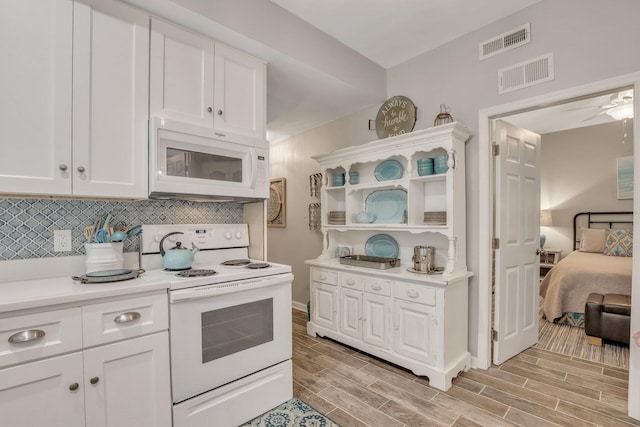 kitchen with light wood-type flooring, white appliances, ceiling fan, and white cabinets