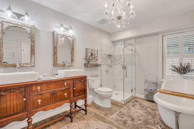 full bathroom featuring vanity, separate shower and tub, hardwood / wood-style flooring, toilet, and a notable chandelier