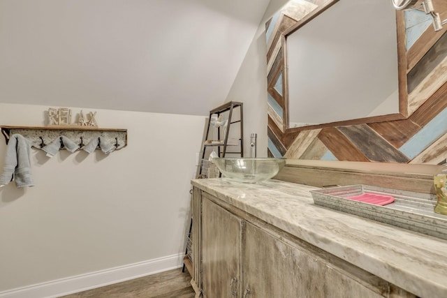 bathroom featuring vanity, vaulted ceiling, and hardwood / wood-style floors