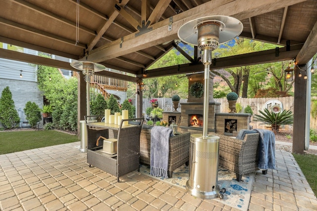 view of patio with an outdoor stone fireplace and a gazebo