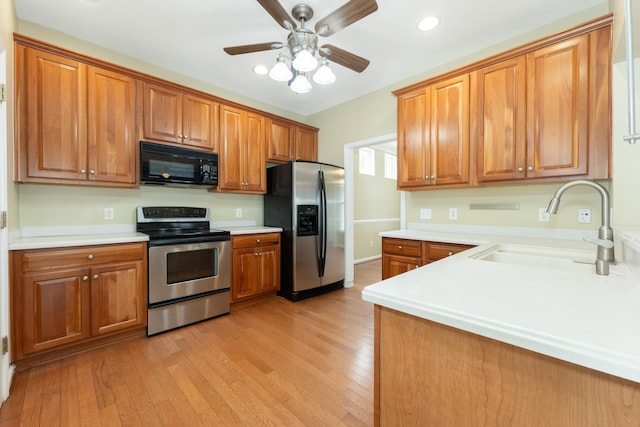 kitchen with ceiling fan, light wood-type flooring, sink, and appliances with stainless steel finishes