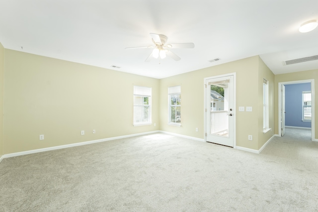 spare room featuring ceiling fan, a healthy amount of sunlight, and light carpet