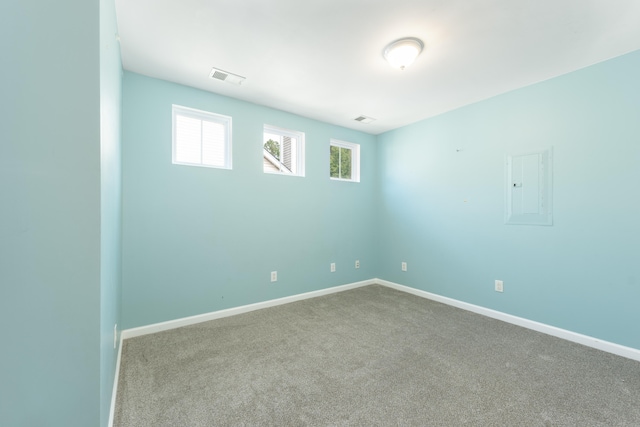 empty room featuring light carpet and electric panel