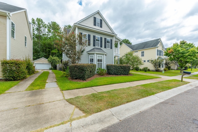 view of front of house with a front yard, an outdoor structure, and a garage