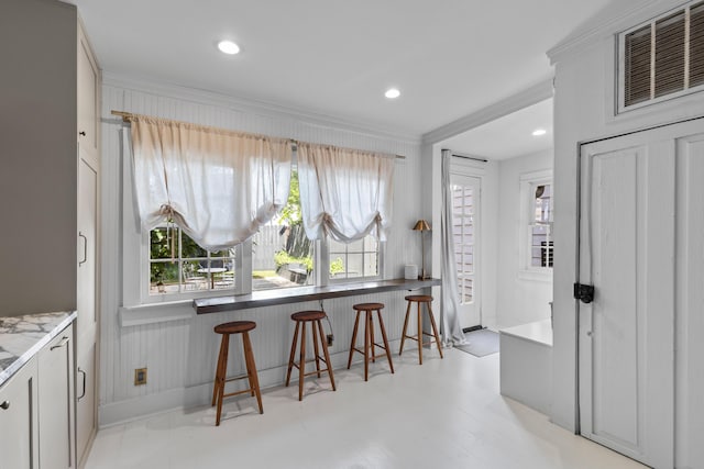 176 Smith St, Charleston, SC 29403 - kitchen featuring crown molding, a breakfast bar area, recessed lighting, and light stone counters