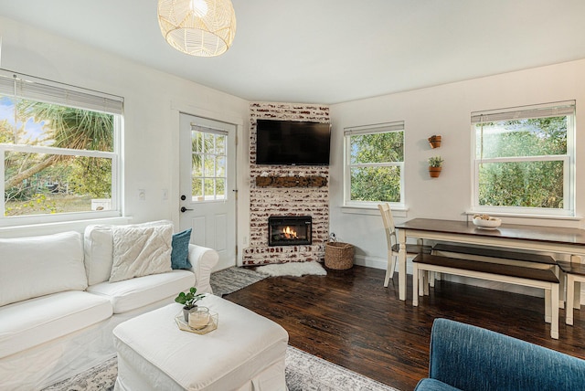 living room with wood-type flooring and a brick fireplace