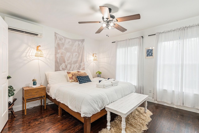 bedroom featuring ceiling fan, dark hardwood / wood-style floors, and an AC wall unit