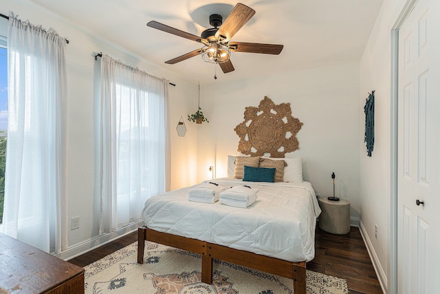 bedroom with multiple windows, ceiling fan, and dark wood-type flooring