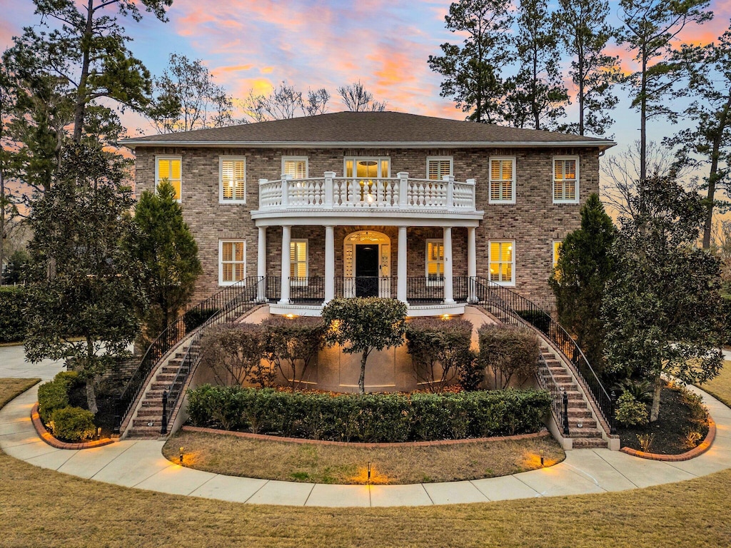 colonial house with a lawn and a balcony