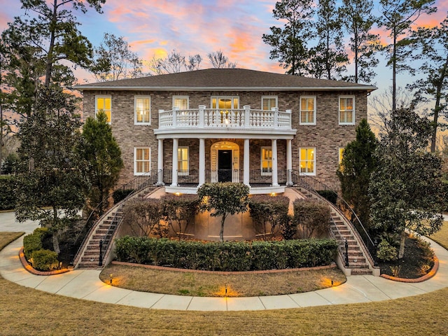 colonial house with a lawn and a balcony