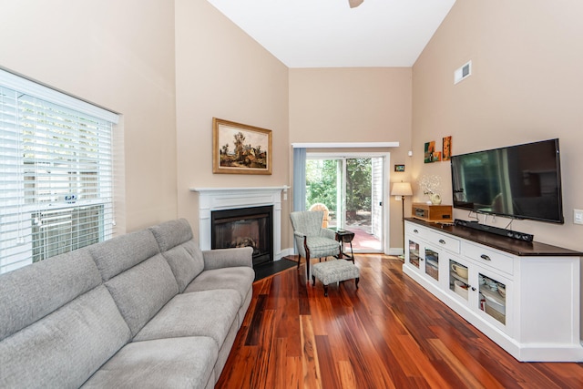 living room featuring dark wood-type flooring and high vaulted ceiling