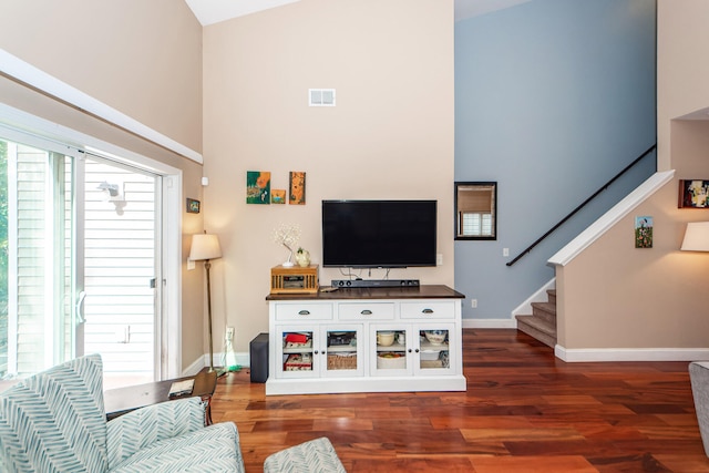 living room featuring high vaulted ceiling and dark hardwood / wood-style floors