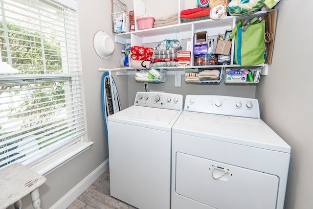 laundry area with independent washer and dryer and light hardwood / wood-style floors