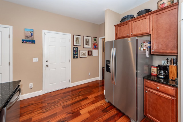 kitchen with dark stone countertops, appliances with stainless steel finishes, and dark hardwood / wood-style floors