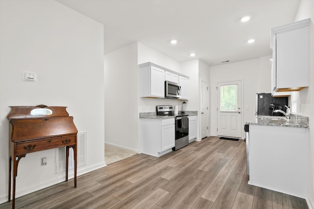 309 Sedona Dr, Summerville, SC 29486 - kitchen featuring stainless steel appliances, light wood-style floors, white cabinetry, light stone counters, and recessed lighting