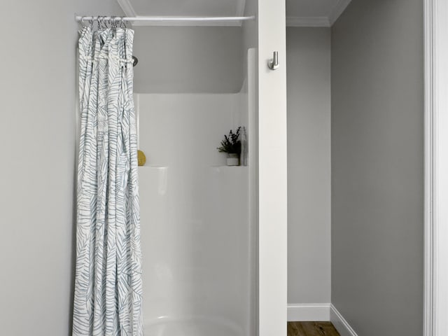 full bath with ornamental molding, curtained shower, wood finished floors, and baseboards