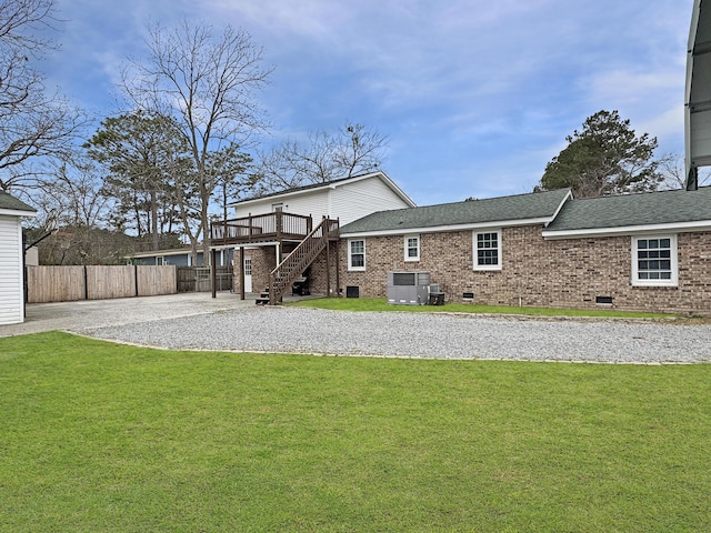 rear view of house with fence, stairs, a yard, crawl space, and gravel driveway