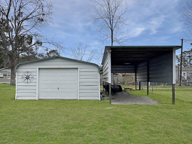 detached garage with driveway, fence, and a carport