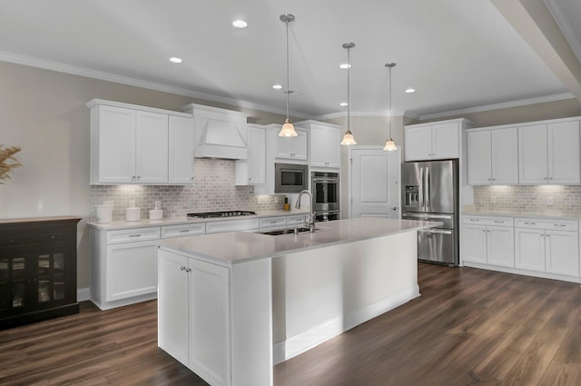 kitchen with appliances with stainless steel finishes, white cabinetry, decorative light fixtures, sink, and custom exhaust hood