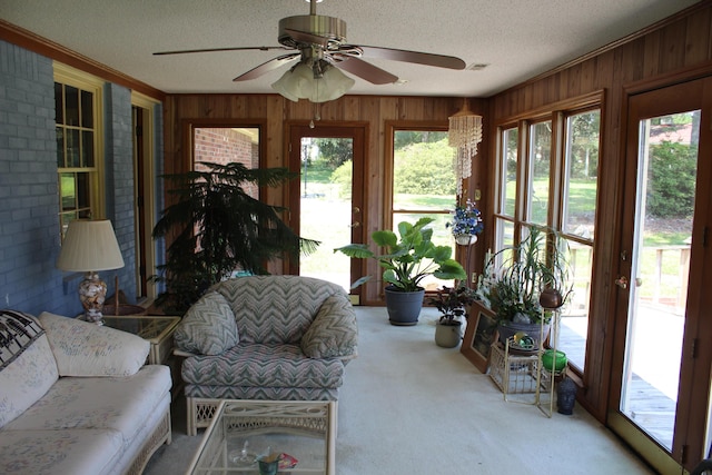 sunroom featuring ceiling fan and plenty of natural light