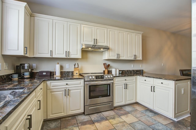 kitchen with stainless steel electric range oven, dark stone countertops, and white cabinetry