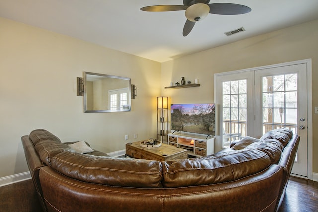 living room with ceiling fan and dark hardwood / wood-style flooring