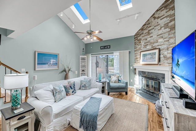 166 River Breeze Dr, Charleston, SC 29407 - living area featuring a skylight, high vaulted ceiling, rail lighting, light wood-type flooring, and a stone fireplace