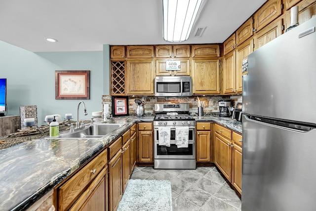 166 River Breeze Dr, Charleston, SC 29407 - kitchen featuring stainless steel appliances, a sink, brown cabinetry, dark countertops, and backsplash