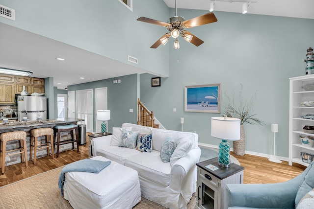166 River Breeze Dr, Charleston, SC 29407 - living area featuring light wood-style floors, ceiling fan, rail lighting, high vaulted ceiling, and stairs