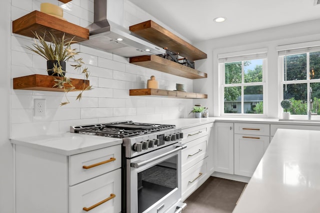 1151 Camellia Dr, Mount Pleasant, SC 29464 - kitchen featuring stainless steel stove, open shelves, wall chimney range hood, backsplash, and white cabinetry