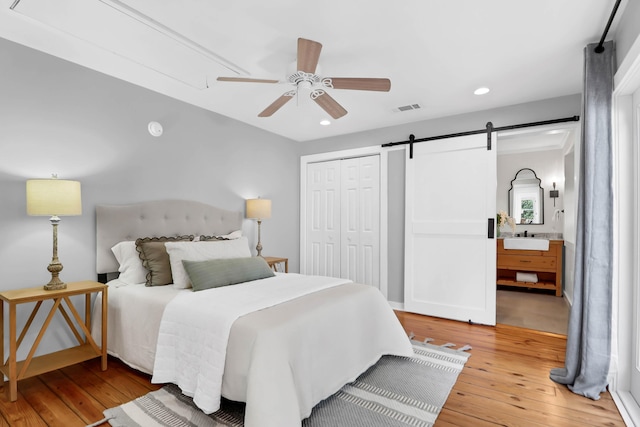 1151 Camellia Dr, Mount Pleasant, SC 29464 - bedroom with a barn door, light wood-style floors, a sink, a closet, and recessed lighting