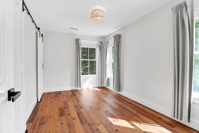1151 Camellia Dr, Mount Pleasant, SC 29464 - spare room featuring a barn door, baseboards, and light wood-style floors