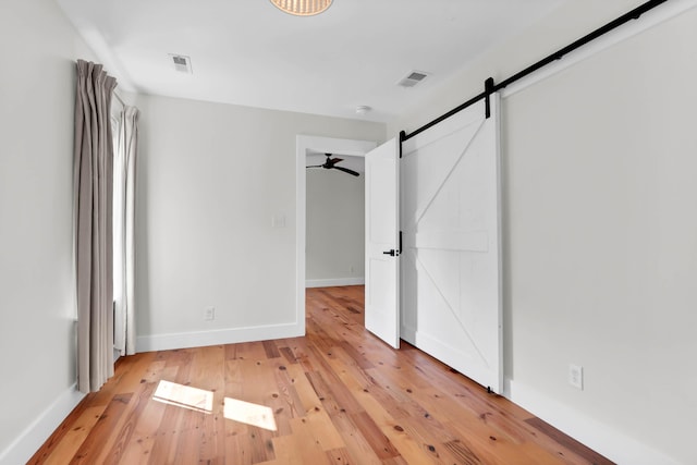 1151 Camellia Dr, Mount Pleasant, SC 29464 - unfurnished bedroom featuring light wood finished floors, a barn door, and baseboards
