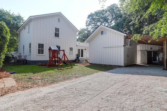 1151 Camellia Dr, Mount Pleasant, SC 29464 - rear view of house with board and batten siding, gravel driveway, and a lawn