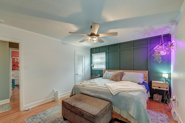 bedroom featuring crown molding, a closet, a textured ceiling, and light wood-type flooring