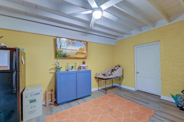 clothes washing area with hardwood / wood-style flooring, washer and dryer, and brick wall